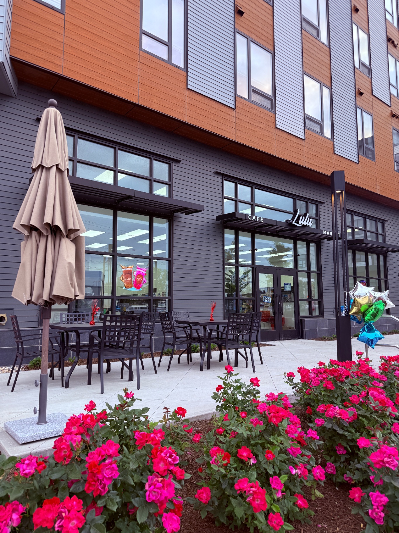 Outdoor patio and rose garden at the entrance of Lulu Market & Cafe in Everett, MA